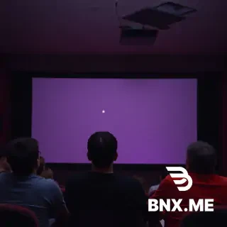 Broken down movie theater but a couple of people watching the screen while they are watching the broken projector screen