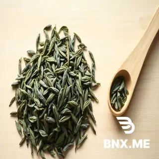 A close-up overhead photograph of realistic loose-leaf tea similar to those in the attached image, on a light-colored wooden surface, soft natural daylight from the left, shallow depth of field. The leaves are clearly visible, intact, with rich green-grey tones and some silvery tips. A small wooden measuring spoon with a few leaves is placed beside the pile. Composition is calm and minimal, with negative space on the right side suitable for text overlay. Editorial food photography style, warm and natural, no artificial filters, no people, no text, no logos. 16:9 horizontal orientation, web-optimized resolution.