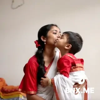 A Bangladeshi girl wearing red blouse without design white saree and nosepin kissing her son